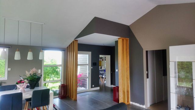 Agencement intérieur : poteaux habillés de bois et caisson de plafond dans un séjour