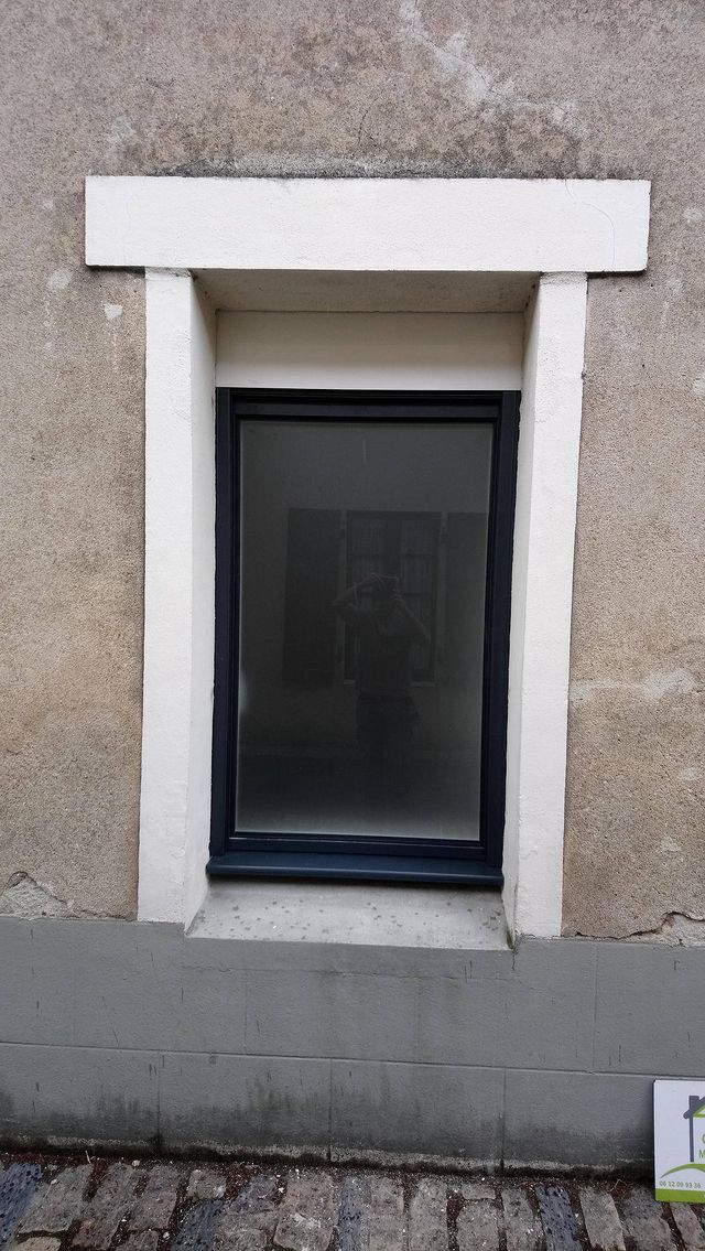 Fenêtre gris anthracite dans un encadrement en pierre, à Oudon