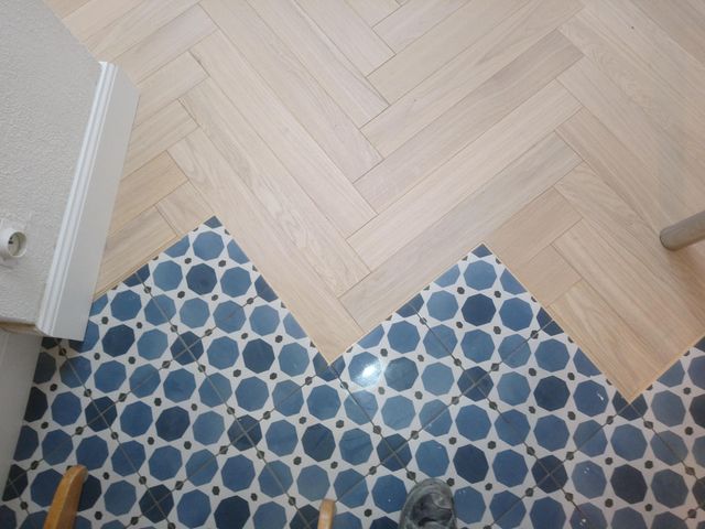 Jonction en zigzag entre un parquet point de Hongrie et des carreaux de ciment, à Nantes