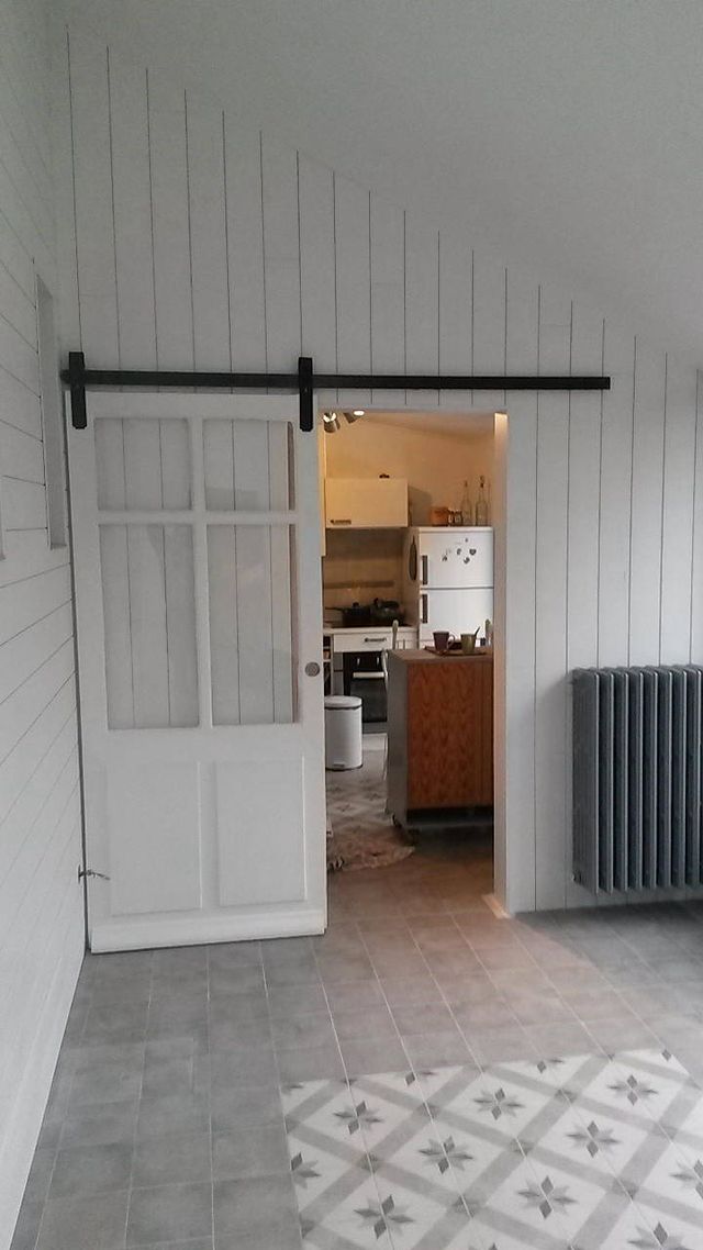 Porte coulissante sur rail apparent ouverte sur la cuisine